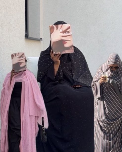 Three women wearing pink, black dotted and striped abayas by Luna Habibty